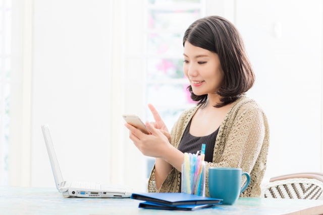 職場でスマホを見る女性